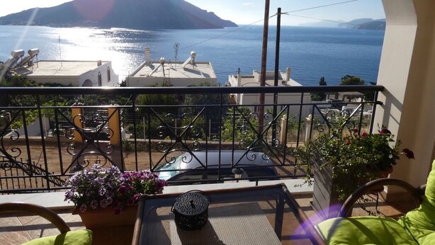 A balcony with a view of the sea and a mountain.
