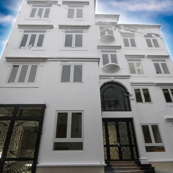A multi-story building with a symmetrical facade, large windows, and a central entrance with a decorative arch.