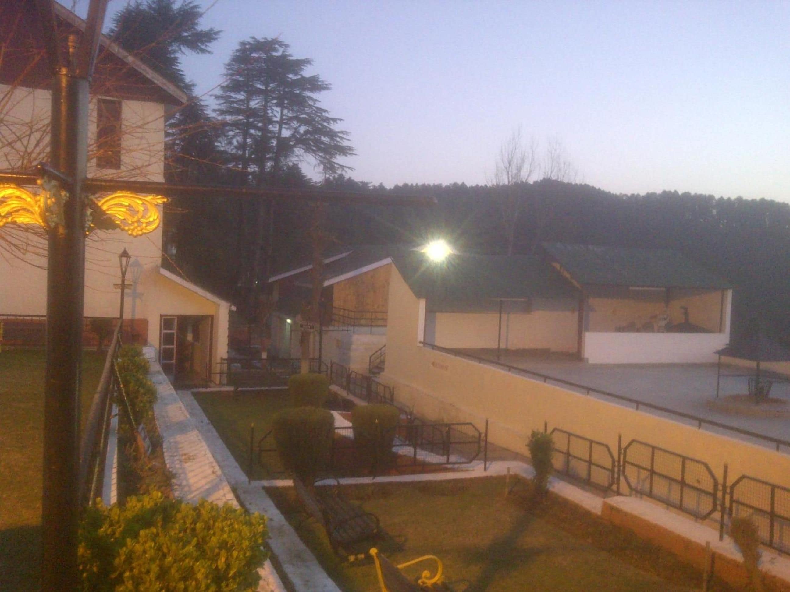 A building with multiple rooms, a covered outdoor area, and a fenced garden.