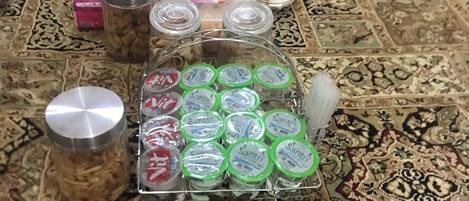 Una mesa con diversos alimentos y recipientes, incluyendo frascos, latas y un tazón de maní.