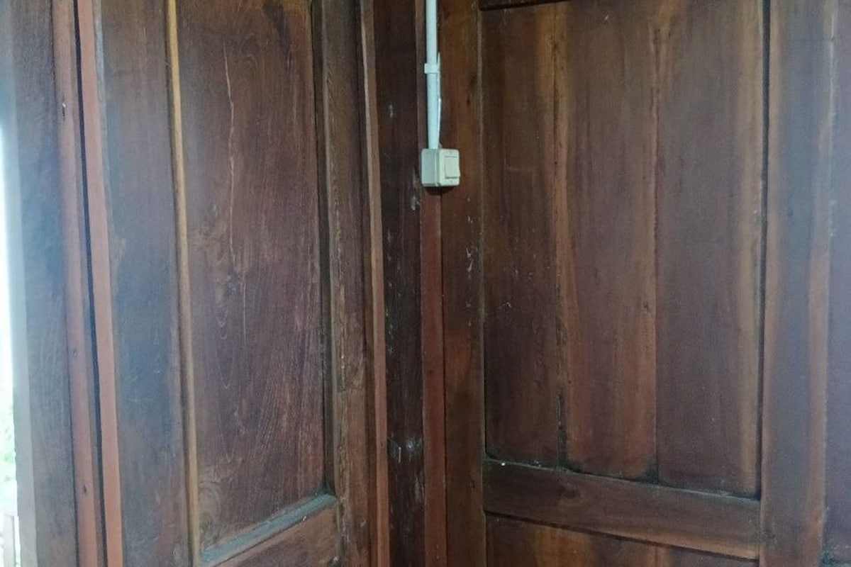 Eine Holztür mit einem Metallriegel.