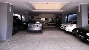 A covered parking garage with multiple cars parked. - Giant Kost (Gading Serpong)