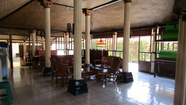 A spacious indoor area with high ceilings, large pillars, and a tiled floor. - Hotel Family Syariah 1 (Parangtritis)