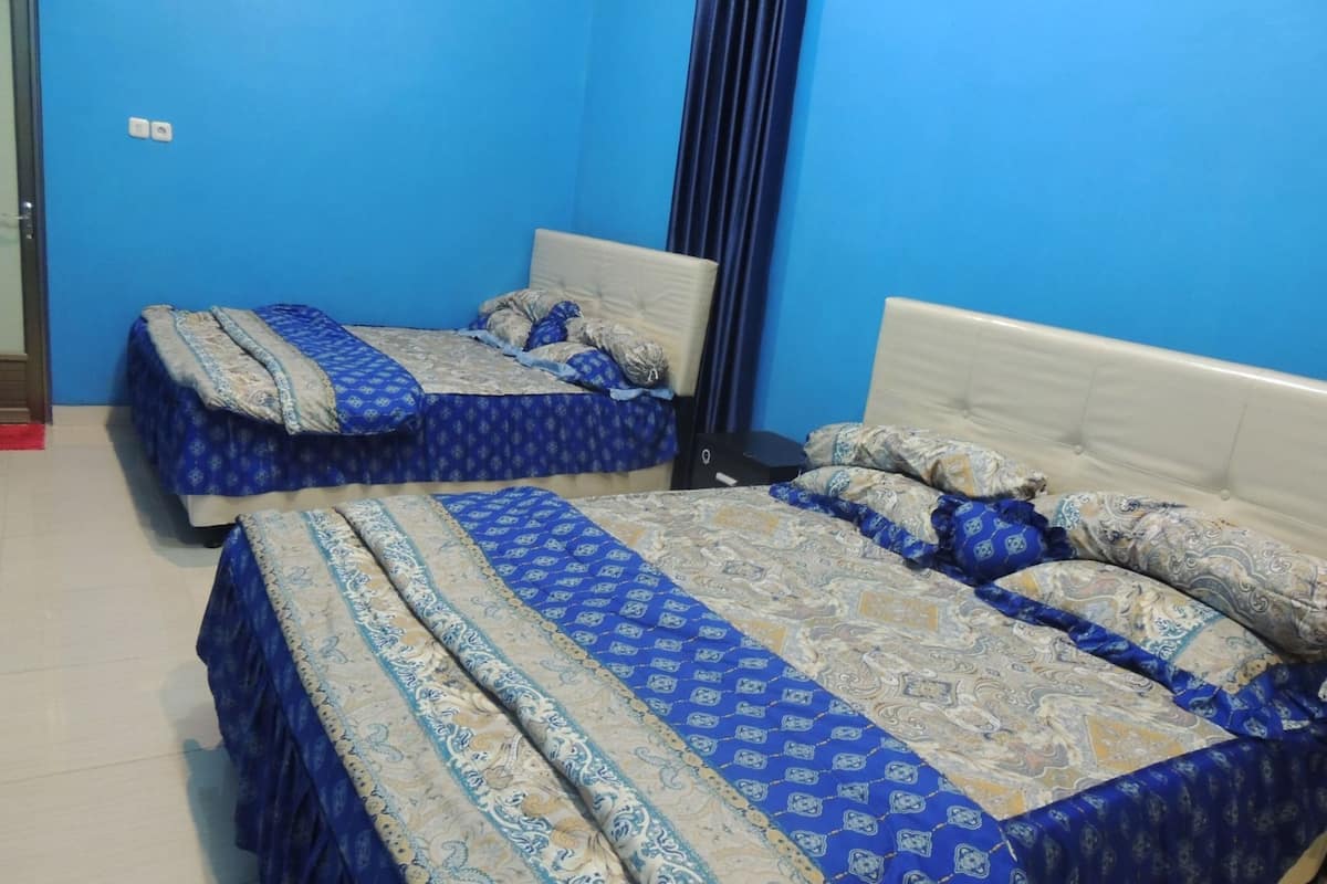 A room with two beds, each with patterned bedding and a headboard.