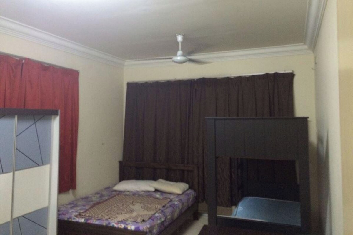 Una camera da letto con un letto a castello, una ventola a soffitto e un'ampia finestra con tende.