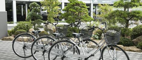 Une rangée de vélos est stationnée devant un bâtiment, et une pancarte indique un espace réservé au stationnement.