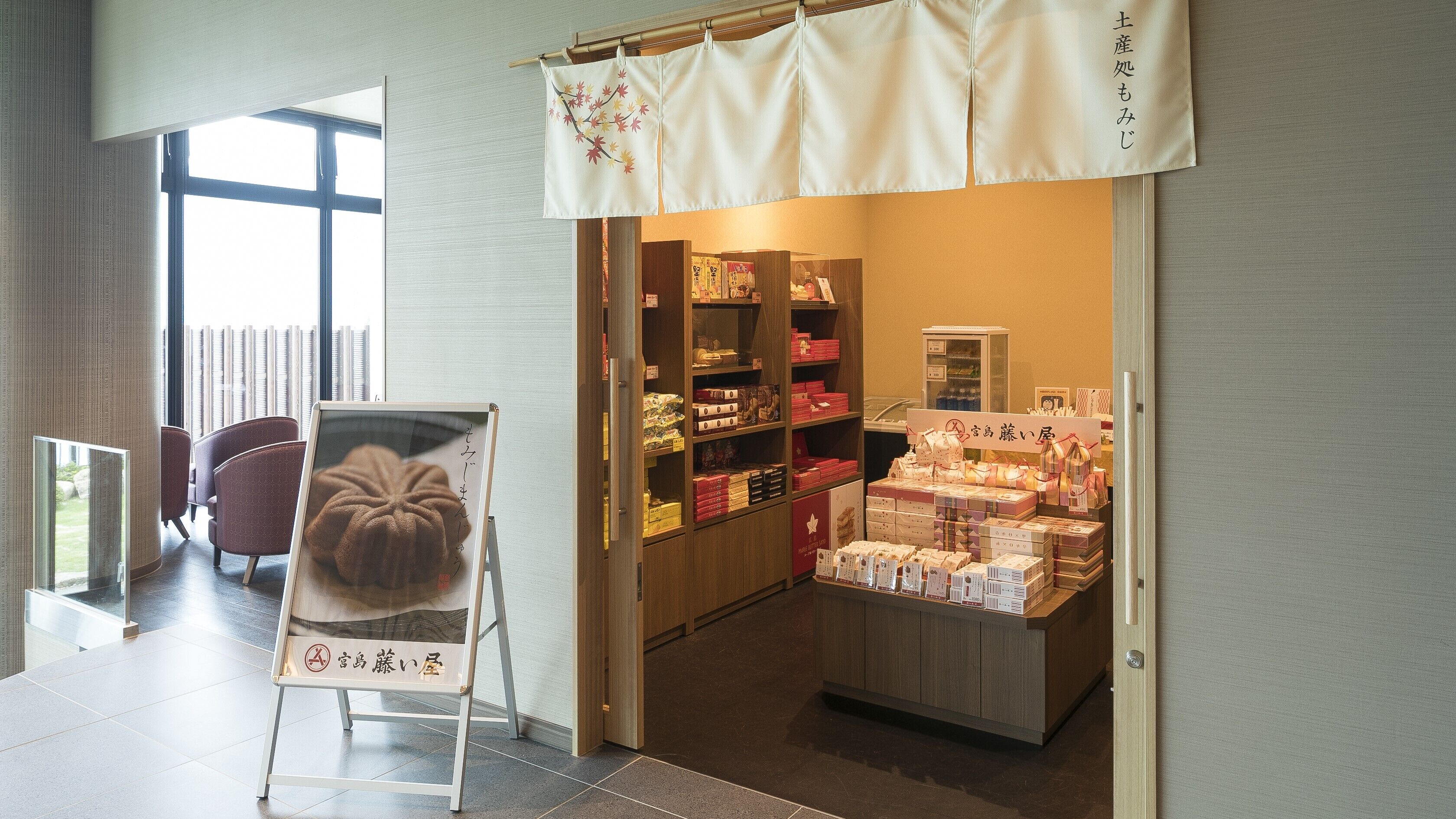 A hotel lobby with a display of packaged goods and a signboard.