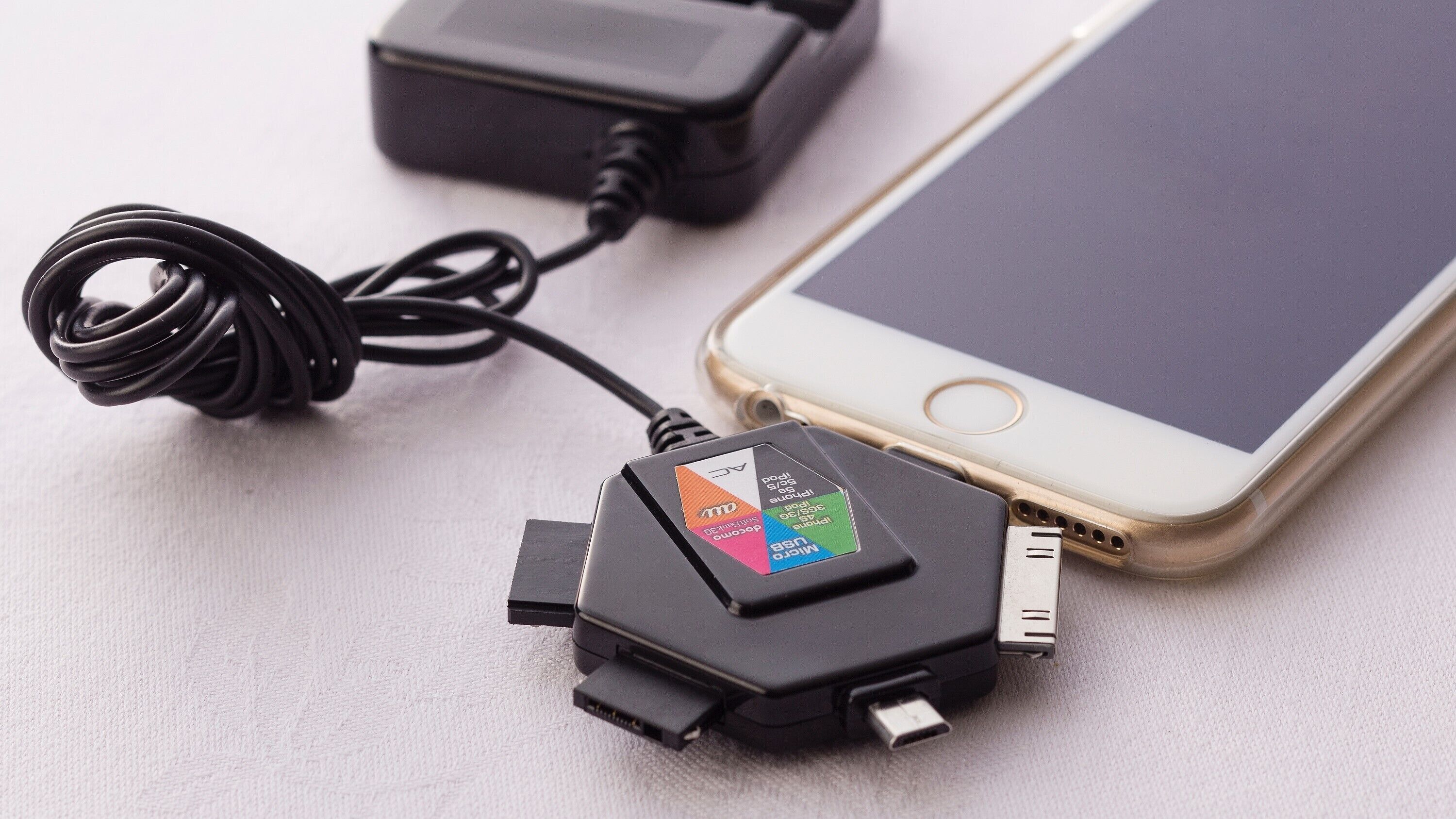 Un teléfono inteligente conectado a un cargador, con puerto micro-USB y puerto USB-C.