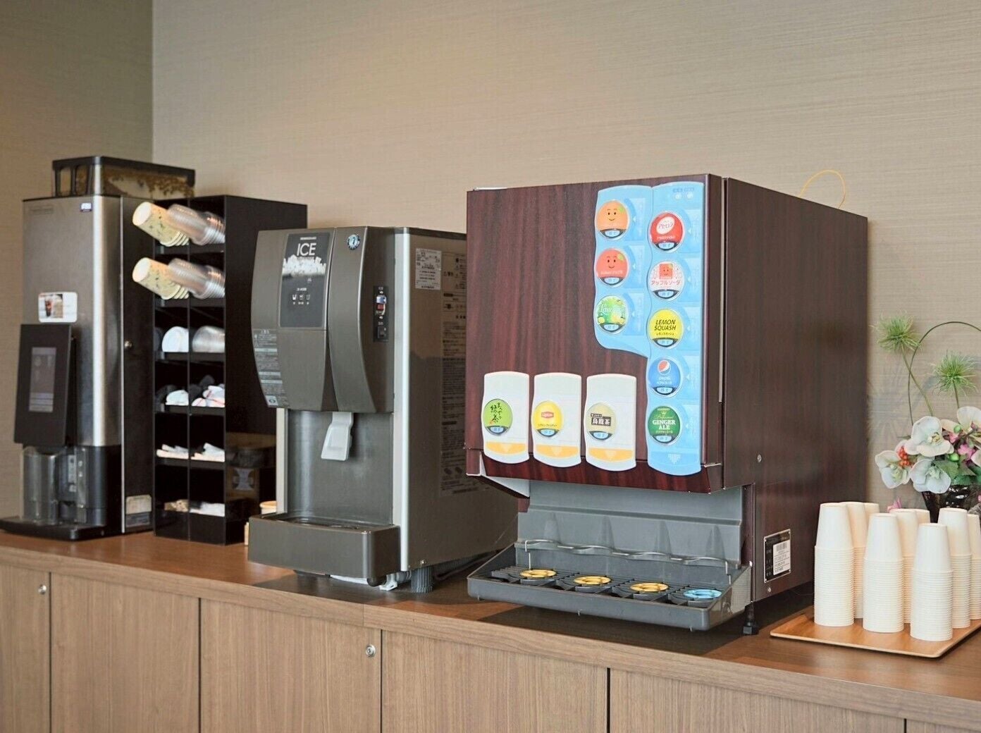 A coffee station with a coffee machine, a beverage dispenser, and a selection of drinks.