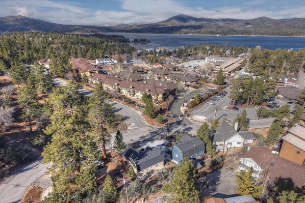 Vista aérea de una zona residencial con casas, carreteras y un lago al fondo.