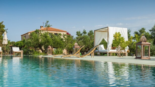 A pool with a wooden bridge, lounge chairs, and a gazebo. - Vrysomylos - Unique Villa on the beach front (Gargalianoi)