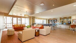 A spacious living area with a sofa set, a coffee table, and a dining area with chairs. - Spacious Furnished Apartment by NRG Stadium (Houston)