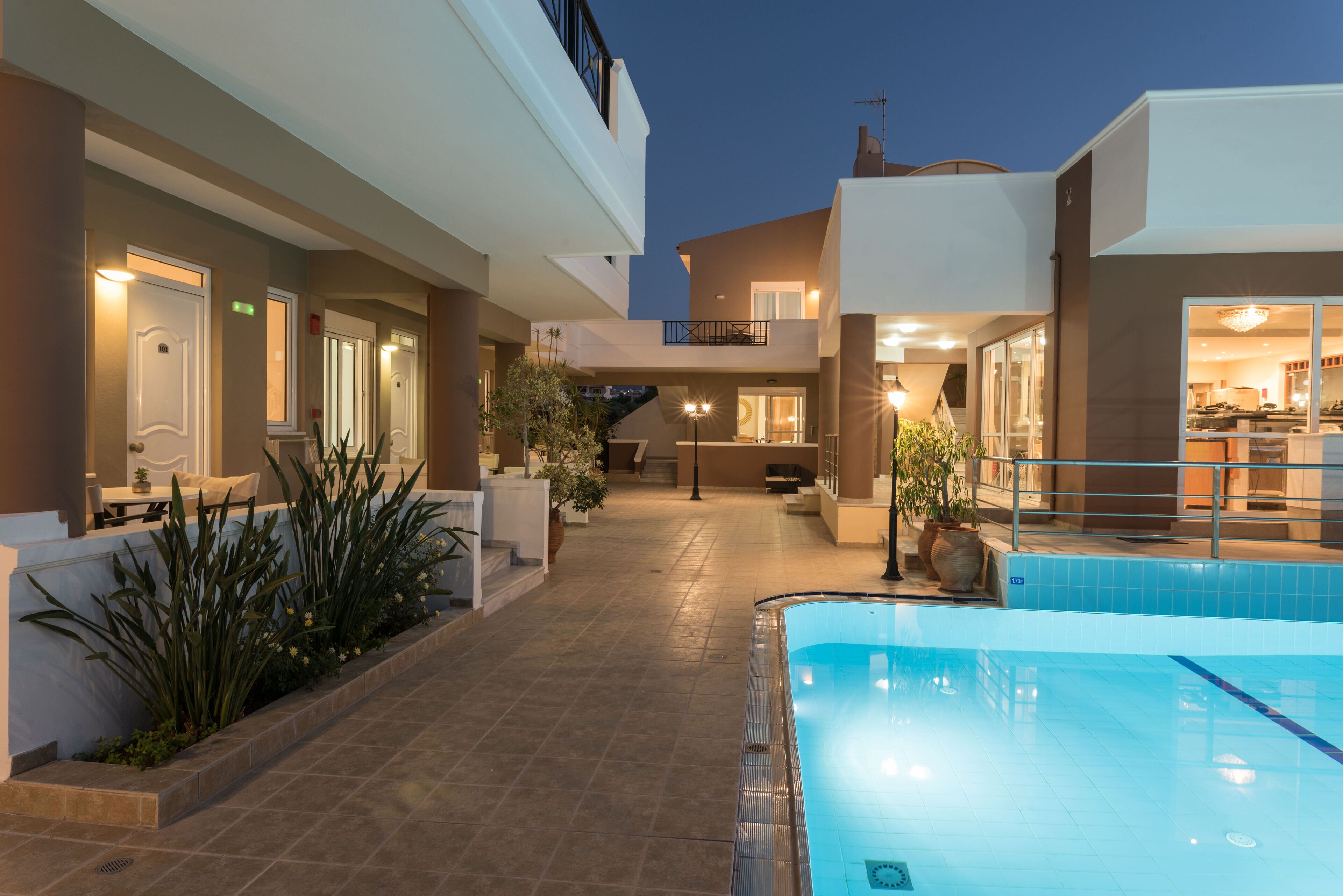 Una piscina al aire libre, sombrillas, sillones reclinables de piscina