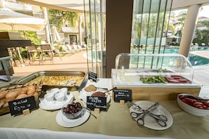 Ein Buffet mit verschiedenen Speisen, darunter gekochte Eier, Oliven und ein Salat.