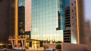 A modern high-rise building with a glass facade and a distinctive corner design. - Al Malqa Elite Hotel (Riyadh)
