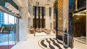A modern lobby with a seating area, marble flooring, and a patterned wall. - Al Malqa Elite Hotel (Riyadh)