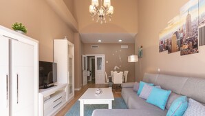 Un salon moderne avec un canapé, un téléviseur, un meuble blanc et un tableau représentant un paysage urbain.