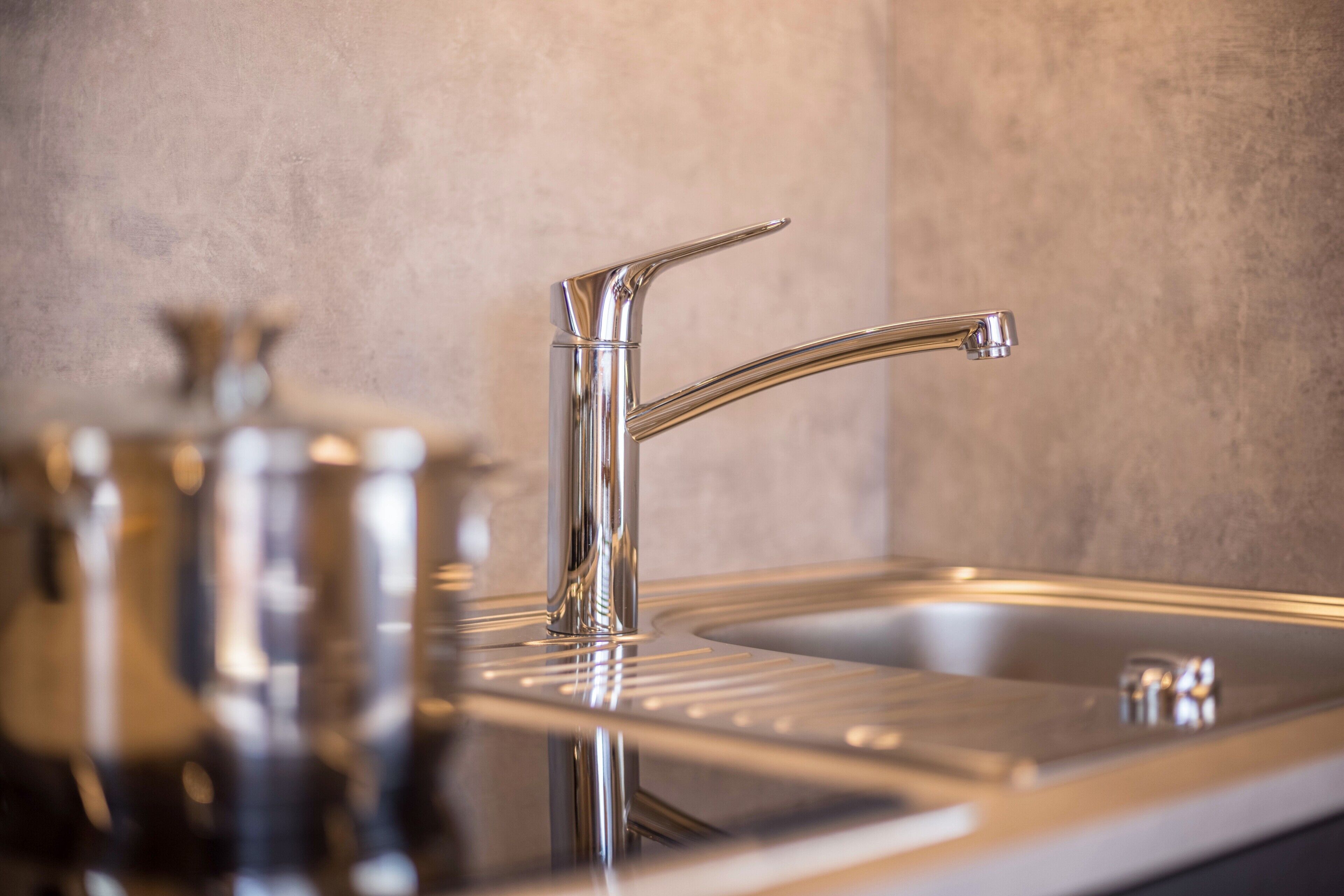 Una cocina moderna con un lavamanos de acero inoxidable, un grifo y una encimera.