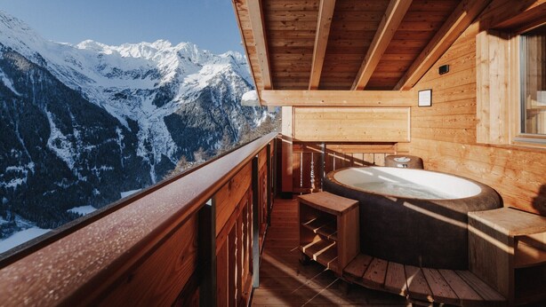 A wooden cabin with a hot tub and a view of snow-capped mountains. - Holiday Home "Chalet Henne-Hochgruberhof" in Idyllic Mountain Location with Own Sauna (Mühlwald)