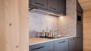 A modern kitchen with grey cabinets, a stainless steel sink, and a built-in oven.
