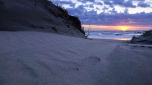 Una playa con un atardecer de fondo.
