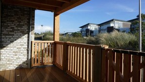 A wooden deck with a brick wall and a view of modern buildings in the background.