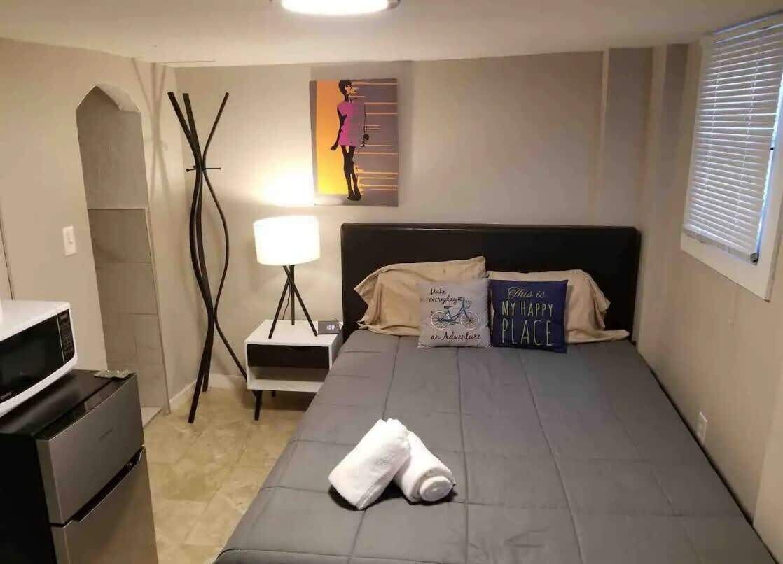 Une chambre d’hôtel avec un lit, un bureau doté d’une lampe, un four à micro-ondes et une affiche accrochée au mur.