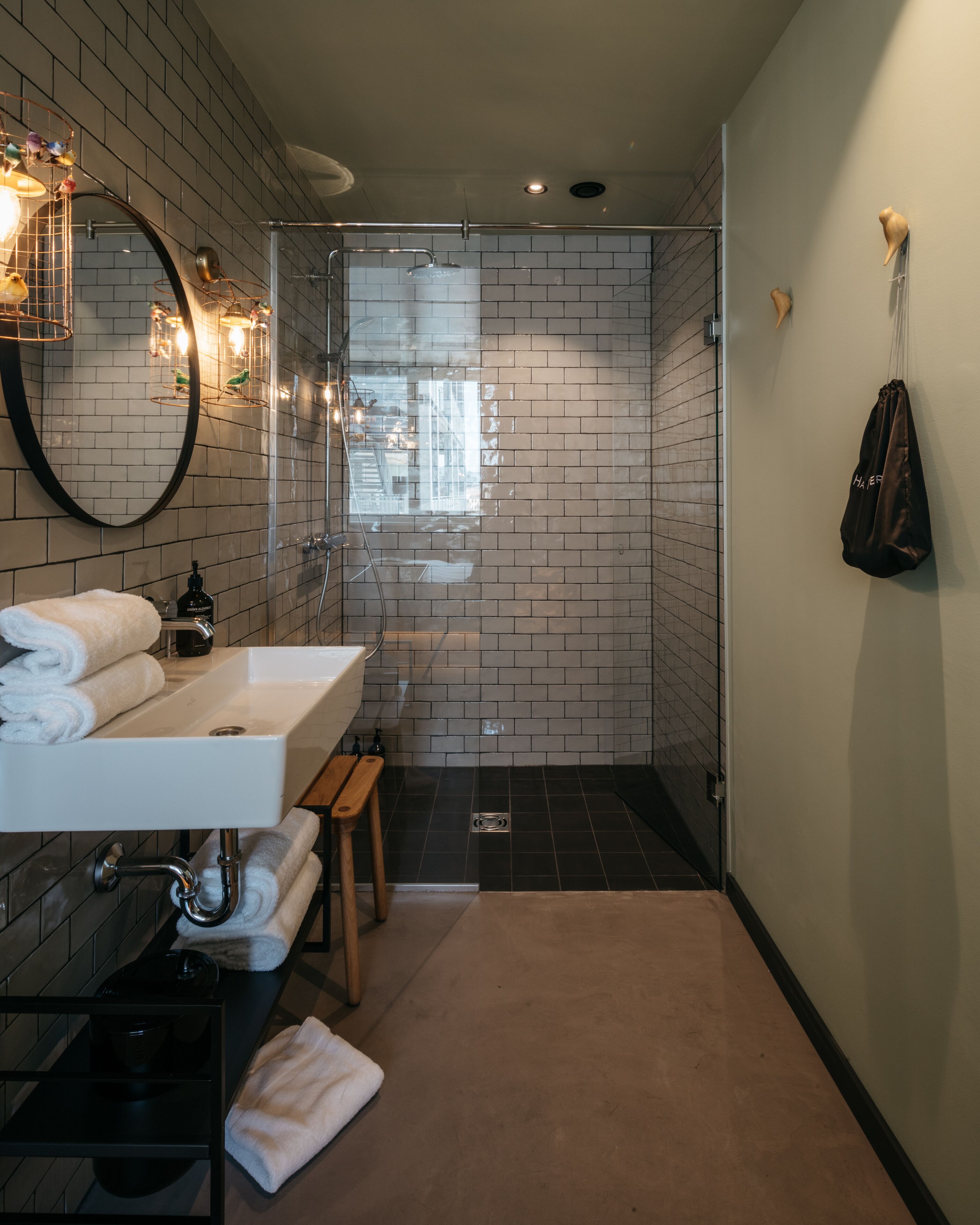 Un bagno moderno con lavandino bianco, specchio e zona doccia.