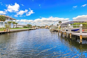 A canal with a white building on the left and a covered structure on the right. - Home on Water | Pool/Lanai Kitchen/Walk to Beach (Marco Island)