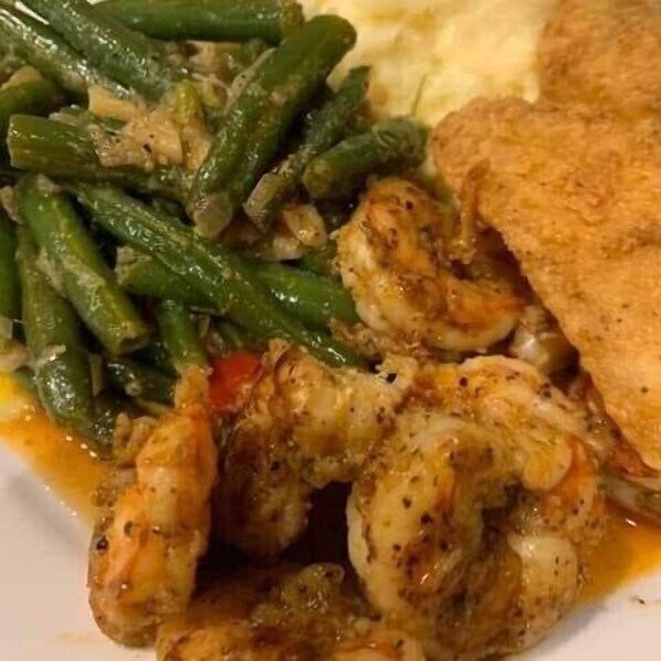 A plate with shrimp, green beans, and a piece of toast.