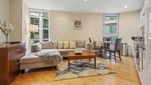A modern living room with a sofa, a coffee table, and a dining area with chairs.