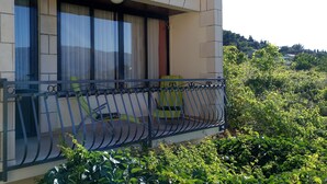 A balcony with a metal railing, a chair, and a table. - Apartment Kata (Lumbarda)