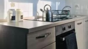 Eine moderne Küche mit einer Edelstahl-Dunstabzugshaube, einem Gasherd und einem eingebauten Backofen.