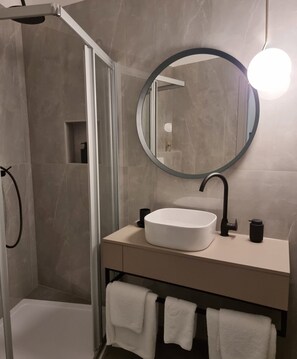 Deluxe studio suite | Badkamer | Een haardroger, handdoeken, zeep, toiletpapier