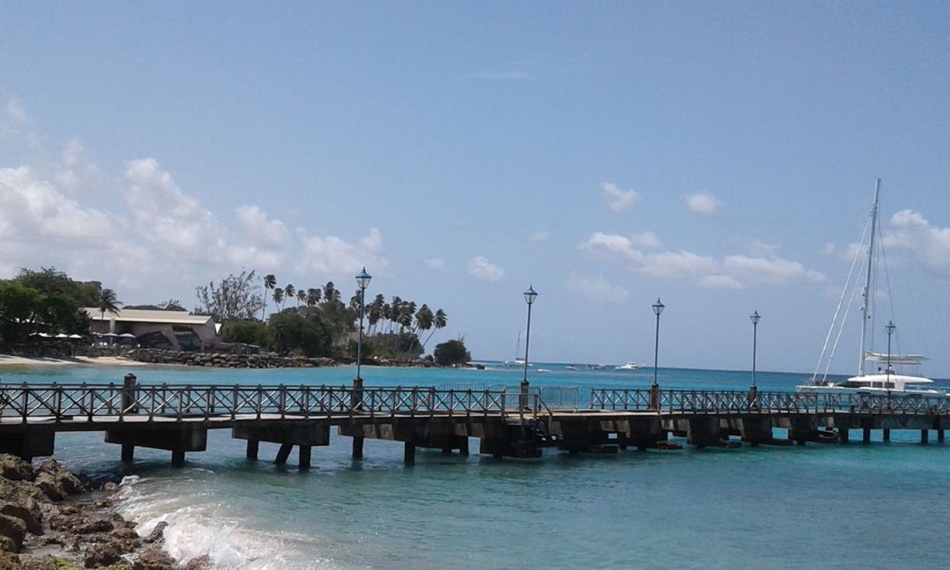 A pier extending into turquoise waters with a clear sky.