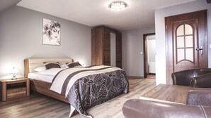 Een slaapkamer met een bed, nachtkastje, kledingkast en een deur.