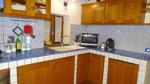 A kitchen with wooden cabinets, a tiled backsplash, and a built-in oven. - Two-room apartment barn in farmhouse with swimming pool (Scandicci)
