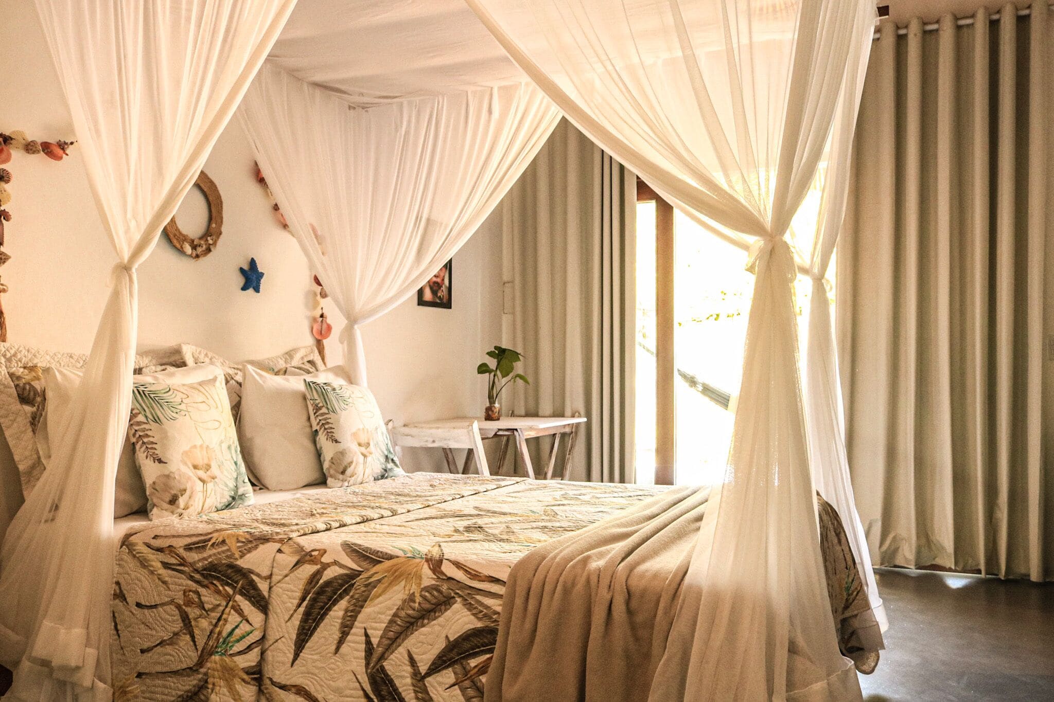 A bedroom with a canopy bed, a small table, and a chair.