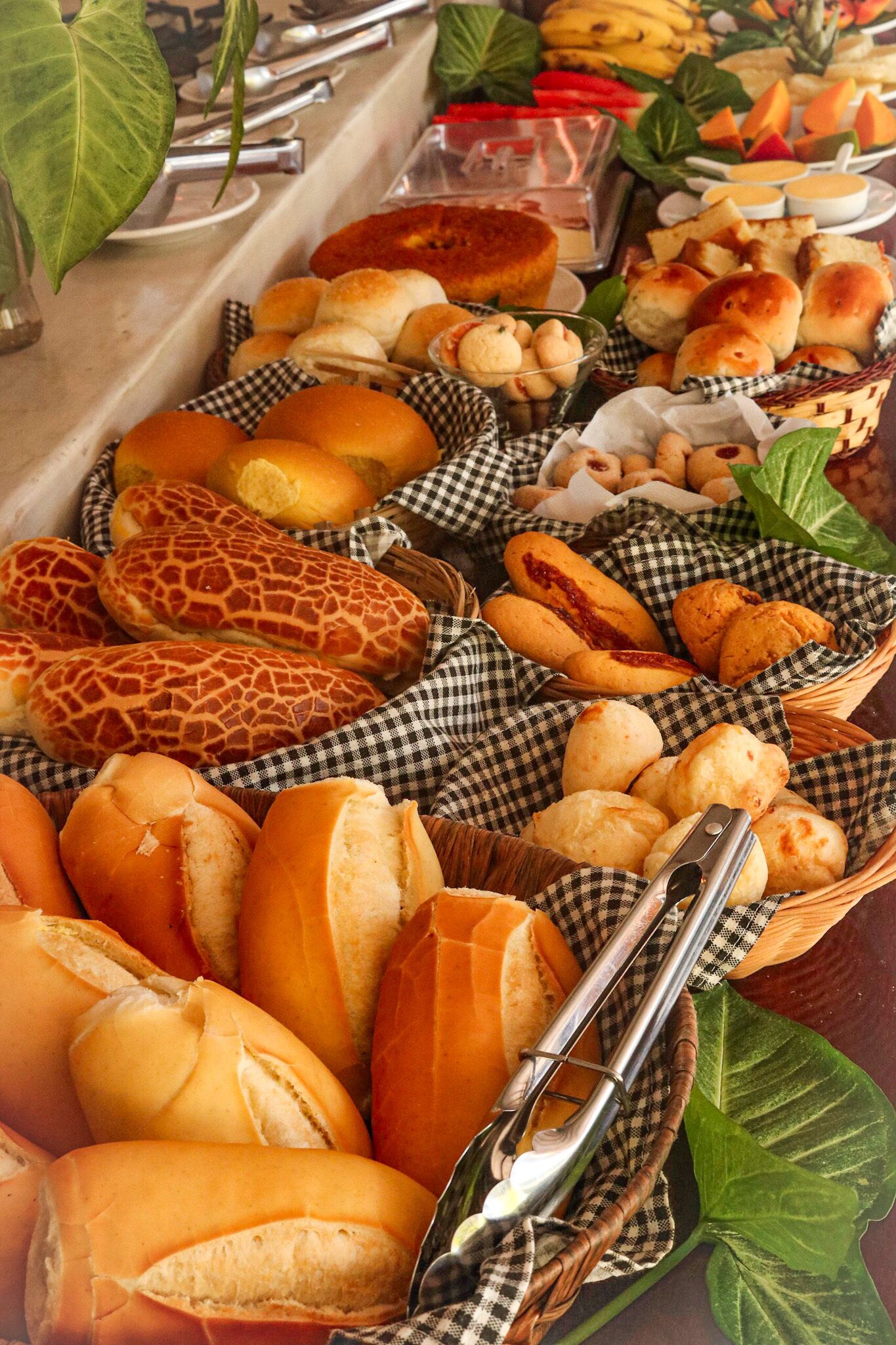 A buffet table with various breads and pastries.