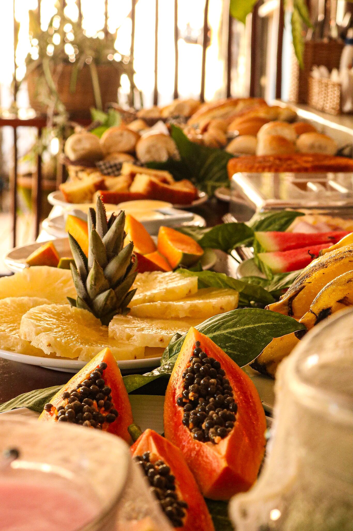 A buffet with various fruits and pastries.