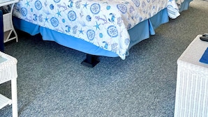 Un dormitorio con dos camas, una mesita y una silla.