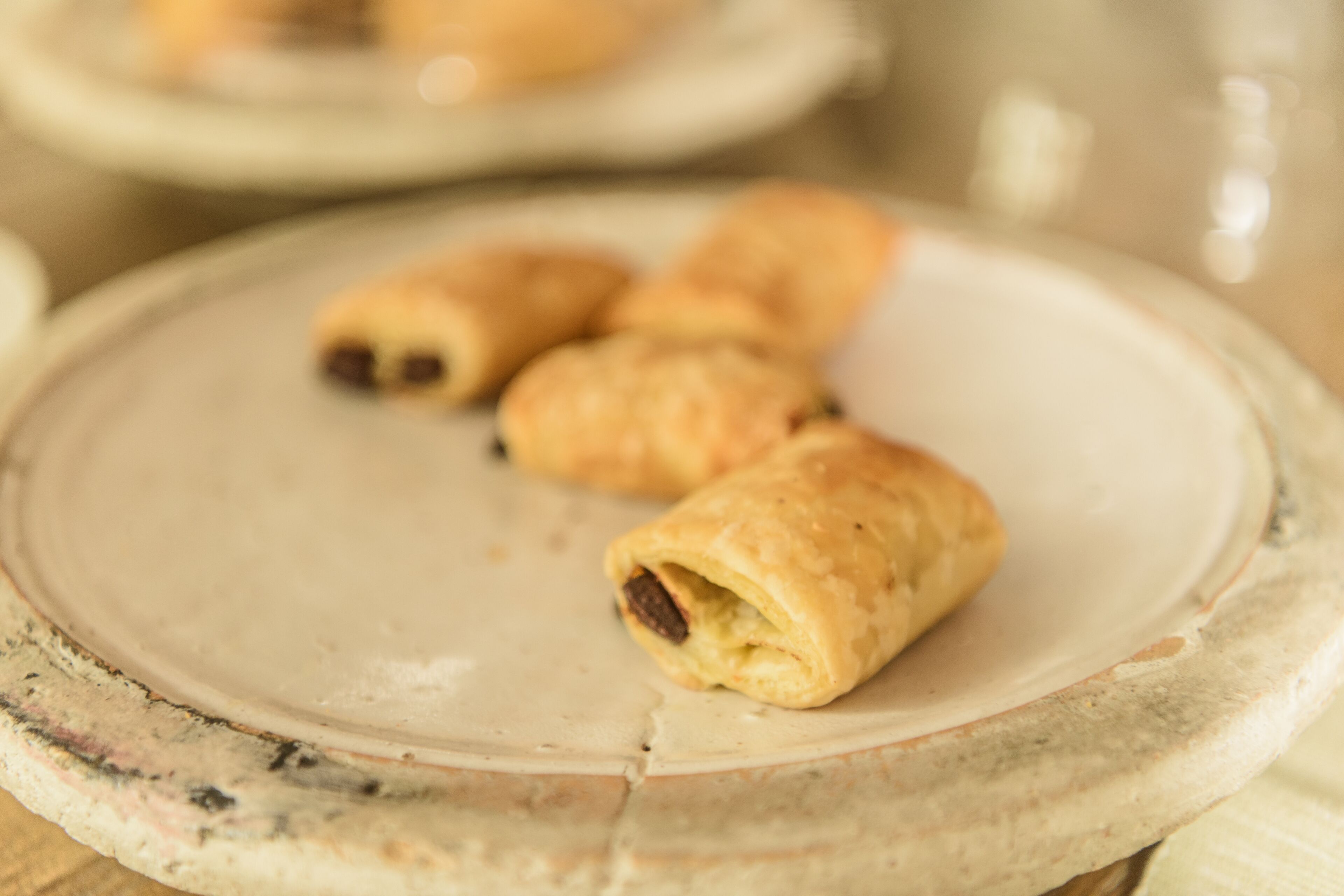 A plate with three pastries on a marble surface.