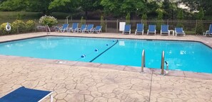 A swimming pool with blue lounge chairs and a stone-tiled deck. - Lake View, Beautiful Condo, Private Beach and Pool (Bolton)