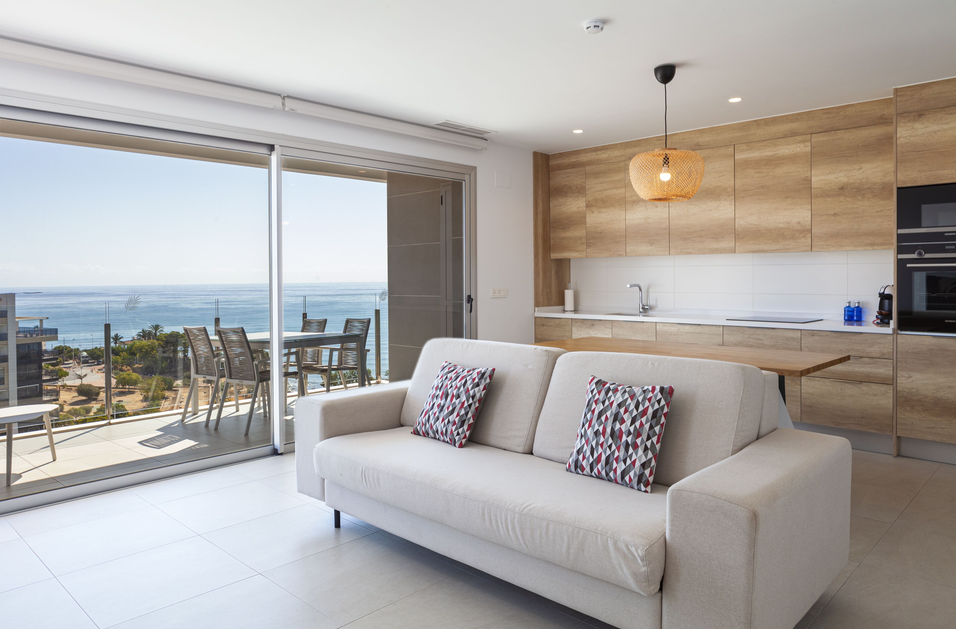 Un salón moderno con un sofá y vista al mar.