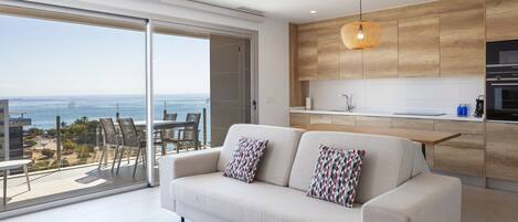 Un salón moderno con un sofá y vista al mar.