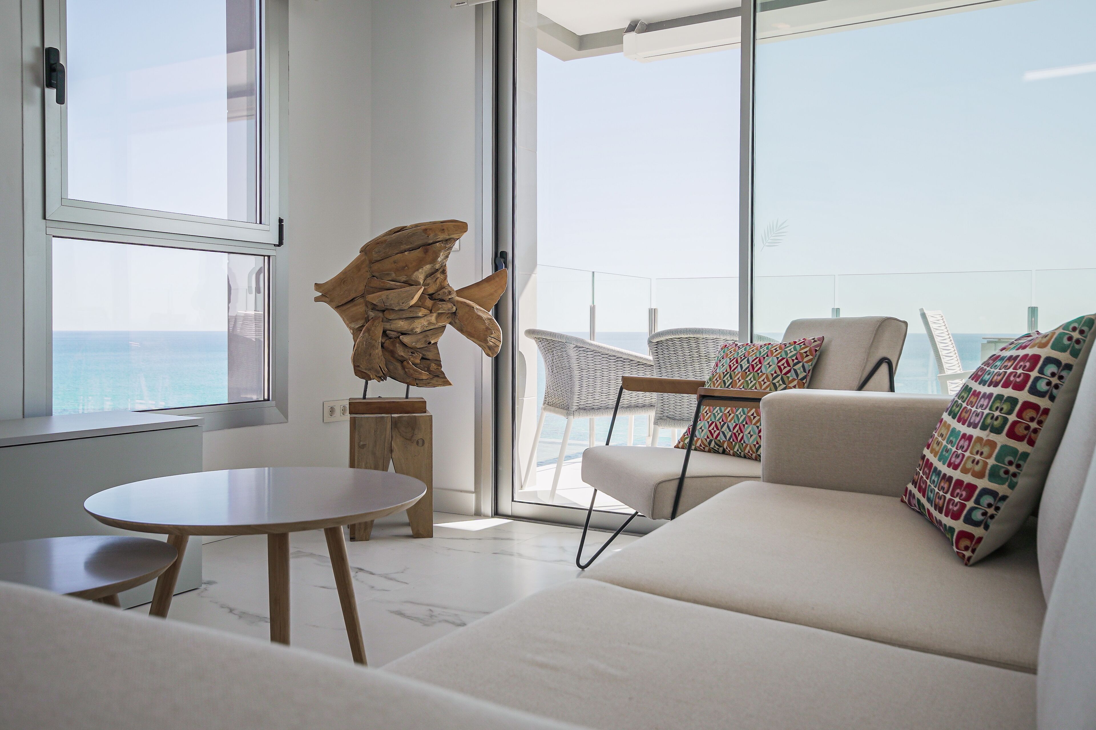A modern living room with a sofa, a round table, and a decorative sculpture.