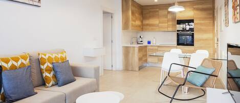 Una sala de estar moderna con un sofá, una mesa redonda y una silla de mimbre.