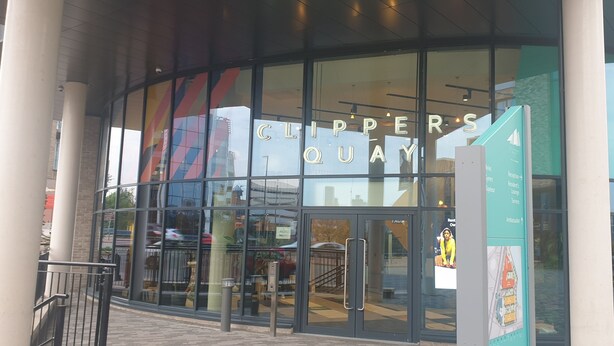 Un edificio moderno con grandes ventanales y un letrero que dice "CLIPPER'S QUAY".
