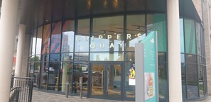 A modern building with large glass windows and a sign reading "CLIPPER'S QUAY". - Quay Apartments Exchange Quay (Salford)