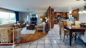 A spacious living area with a dining table, kitchen, and a balcony.
